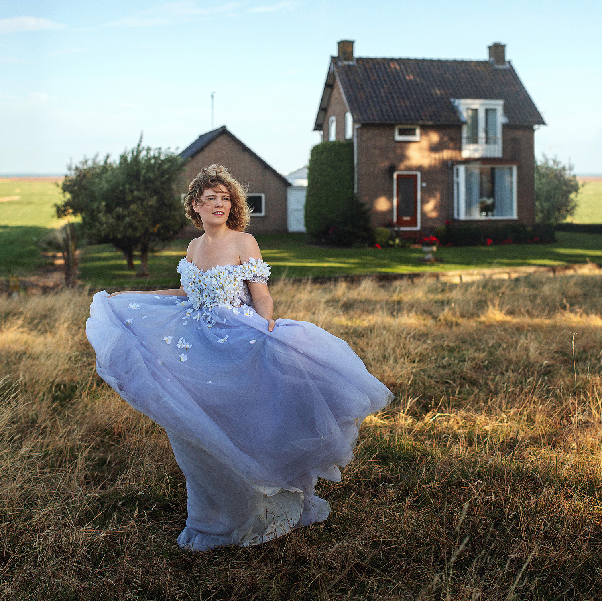 NinaLynn in een lavendelblauwe jurk voor een boerderij